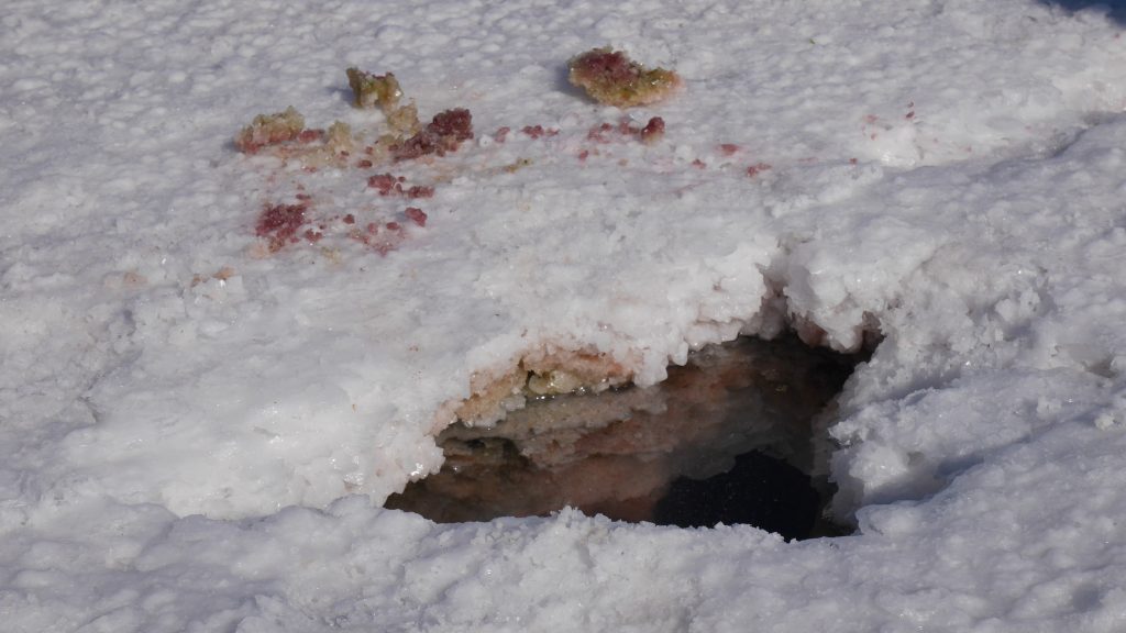 un trou très fin dans la croûte de sel et les minéraux colorés